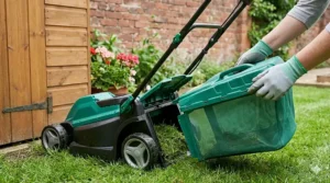 Close-up of a lightweight grass collector box being detached from a lawn mower designed for small gardens.