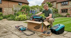 Unboxing a brand new cordless electric lawn mower with a rear roller on a patio.