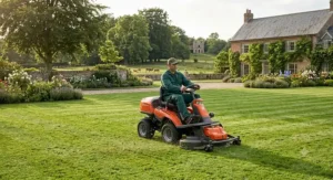 Gardener operating a Husqvarna ride on mower across a manicured countryside estate lawn