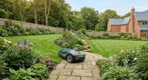 Multi-zone robot lawn mower traversing a paving pathway between two separate large garden lawn areas.