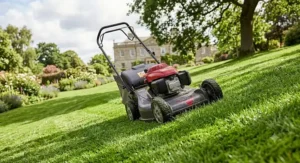 A high performance petrol lawn mower navigating a sloped and undulating large garden with ease