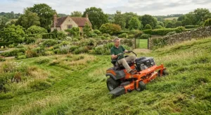 Heavy-duty ride-on lawn mower handling slopes and uneven terrain in a 1-acre country garden.