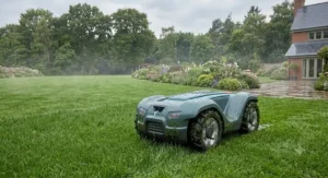 All-weather robot lawn mower equipped with rain sensors trimming damp grass in a large UK garden.