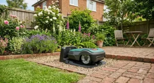 An automatic robotic mower docked at its charging station next to a brick patio.