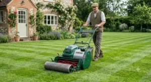 Battery-powered cordless cylinder mower with a heavy steel rear roller producing deep green lawn stripes.
