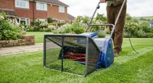 An electric cylinder lawn mower with a front-mounted grass box collecting fine grass clippings.