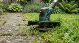 Close-up of an electric grass trimmer cutting overgrown grass along a garden path, ideal for UK back gardens.