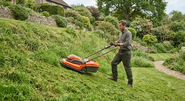 Illustration of a hover mower cutting grass safely on a steep garden slope.
