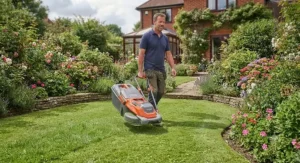 A homeowner easily carrying the best hover mower by its integrated handle.