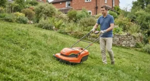 A hover mower gliding easily across a sloped lawn, highlighting its manoeuvrability on uneven ground.