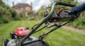 Close-up of the drive lever and controls on a self-propelled lawn mower.