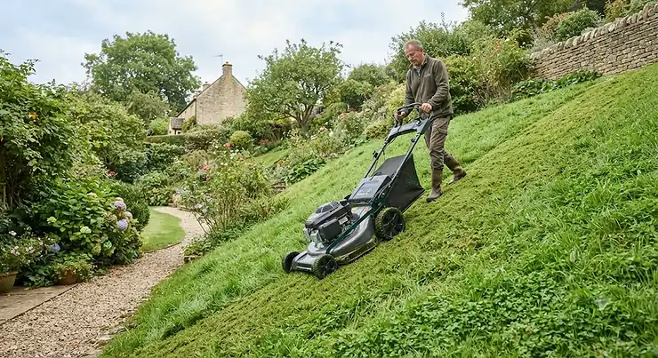 A robust self-propelled lawn mower designed for cutting grass on steep British garden slopes.