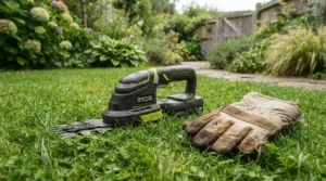 Light grass trimmer resting on green turf beside an older gardener taking a break.